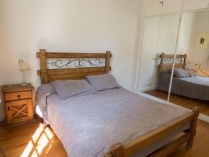 布宜诺斯艾利斯Silencioso departamento antiguo的一间卧室配有一张带木制床头板的床
