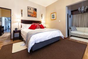 伊丽莎白港Amery House的一间卧室配有一张带红色枕头的床和一张沙发