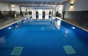 福尔柯克麦克唐纳德伊奇拉度假酒店&SPA的大楼内一个蓝色的大型游泳池