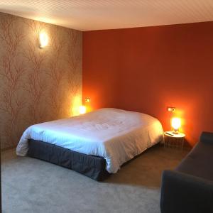 圣伊波利特La bacchante的一间卧室配有一张红色墙壁的床和两盏灯。