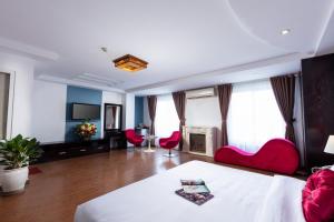 河内Hanoi Amore Hotel & Travel的酒店客房,配有床铺和红色椅子