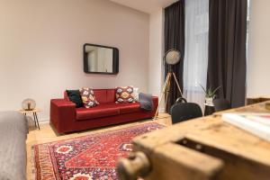 布达佩斯TG Hotel Apartments Budapest的客厅配有红色的沙发和镜子