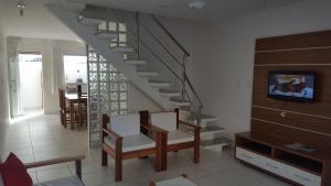 塞古罗港Condomínio Mar da Galiléia - Apto 27的客厅设有楼梯和桌椅