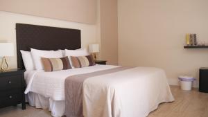 隆达La Perla Blanca - Ronda的卧室配有带枕头的大型白色床