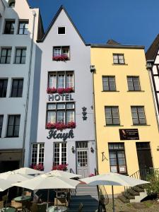 科隆Altstadthotel Hayk am Rhein的大楼前有遮阳伞的酒店