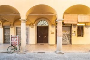 博洛尼亚Residenza Ariosto by Studio Vita的停在有柱子的建筑前的自行车