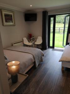 本拉提Tudor Lodge Guest Accommodation的卧室配有一张床和一张桌子及椅子