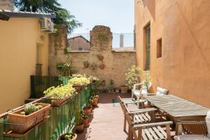 博洛尼亚Petroni 38 by Studio Vita的户外庭院配有桌椅和盆栽植物