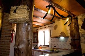 CarcabueyCasa Rural El Tejar Viejo的厨房设有吊在天花板上的篮子