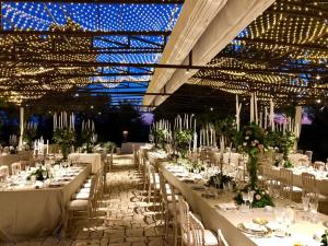 曼杜里亚Masseria Li Reni的宴会厅配有白色的桌椅和灯