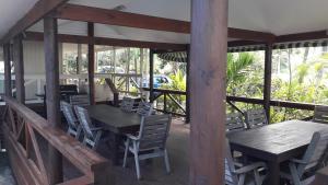 拉罗汤加Te Akapuao Studio Villas的甲板上配有木桌和椅子的用餐室