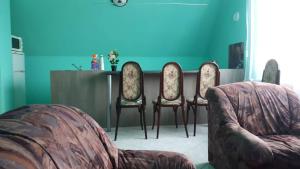 德布勒森Barátságos ház emelete的客厅配有三把椅子和一张桌子