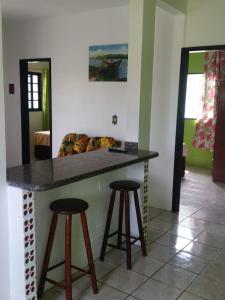 瓜尔达恩巴Moradas Jeane的厨房配有柜台和2个酒吧凳