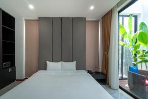 会安Khong Cam Garden Villas的卧室设有白色的床和大窗户