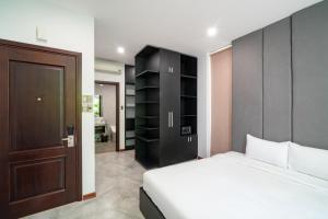 会安Khong Cam Garden Villas的卧室配有白色的床和黑色橱柜。