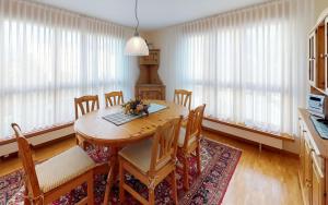 圣莫里茨Surpunt 44的一间带桌椅和窗户的用餐室