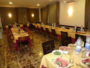 Capistrello德梅斯酒店的一间设有桌椅和盘子的餐厅