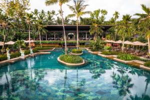 波普托Anantara Bophut Koh Samui Resort的棕榈树和遮阳伞度假村的游泳池