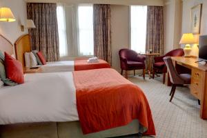 卡莱尔Crown & Mitre Hotel的酒店客房配有两张床和一张书桌