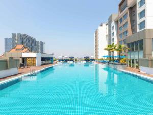 仰光诺富特仰光大酒店的一座位于城市的游泳池,有高大的建筑