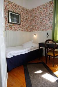 瑟尔沃斯堡Hotell Edgar & Lilla Kök的卧室配有1张床、1张桌子和1把椅子