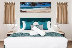 卡伦德拉Ocean Views Resort Caloundra的一间卧室配有一张带蓝色和白色枕头的床