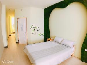 台南格林薇依的一间卧室配有一张白色床和绿色床头板