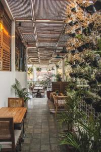 日惹日惹加持酒店的庭院设有长椅和桌子,种植了植物