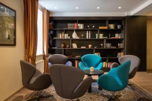 塔林塔林库特兹瓦尔德酒店的图书馆配有椅子、桌子和书架
