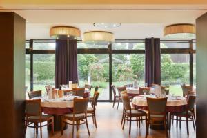 费尔德基希维斯科鲁兹酒店 的一间带桌椅的用餐室和大窗户