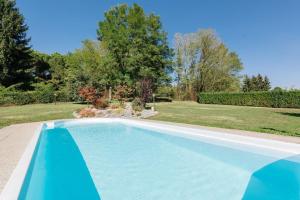Olgiate Comasco罗萨莉娅别墅的一座绿树成荫的庭院中的蓝色游泳池