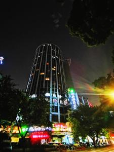 广州Paco Hotel Tuanyida Metro Guangzhou -Free ShuttleBus for Canton Fair的一座高大的建筑,晚上有灯