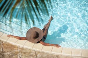 圣吉尔莱班留尼汪岛星礁度假村的戴帽子的女人在游泳池里