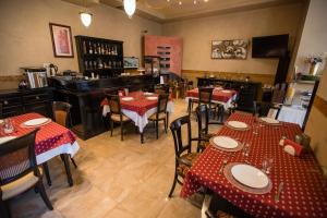 德瓦维纳斯酒店的餐厅设有桌椅,配有红色和白色的桌子