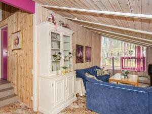 菲耶勒鲁普8 person holiday home in Glesborg的客厅配有蓝色沙发和白色橱柜