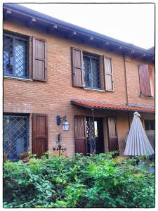 卡斯泰尔夫兰科埃米利亚马切罗堂乡村民宿的前面有雨伞的砖房