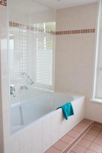 厄伊特霍伦 海特雷克特惠斯酒店的白色的浴室设有浴缸和窗户。
