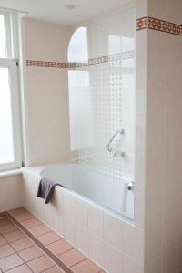 厄伊特霍伦 海特雷克特惠斯酒店的白色的浴室设有浴缸和窗户。