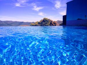 欧鲁普雷图Hotel Recanto do Ouro - Antigo Recanto da Serra的蓝色的海水游泳池,后面有一座建筑
