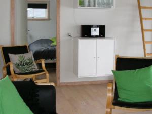 古兹耶姆6 person holiday home in Gudhjem的客厅配有椅子、镜子和床
