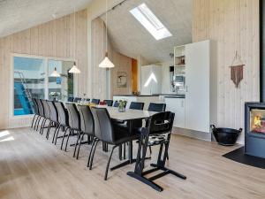 瓦伊比16 person holiday home in Vejby的一间带桌椅的用餐室和一间厨房