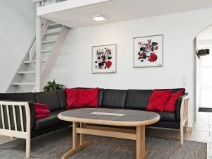 埃贝尔托夫特8 person holiday home in Ebeltoft的客厅配有黑色沙发和桌子