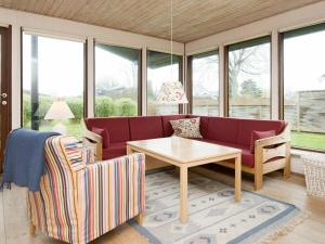 桑德比耶特6 person holiday home in Bjert的客厅配有红色的沙发和桌子