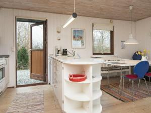 桑德比耶特6 person holiday home in Bjert的厨房配有白色的柜台和桌子