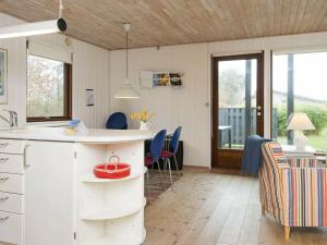 桑德比耶特6 person holiday home in Bjert的厨房以及带桌椅的起居室。