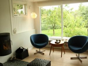 Hornsved4 person holiday home in J gerspris的客厅配有两把椅子、一张桌子和一扇窗户