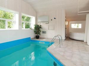 吉利勒杰8 person holiday home in Gilleleje的一间带游泳池、浴缸和水槽的浴室