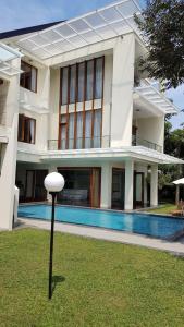 万隆Bukit Dago Palace 22的一座大型白色建筑,在庭院里设有一个游泳池