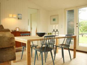 Hornsved4 person holiday home in J gerspris的一间带木桌和椅子的用餐室