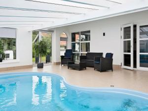 埃贝尔托夫特8 person holiday home in Ebeltoft的客厅设有大型游泳池,配有家具
